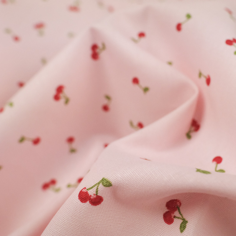Popeline de coton petites cerises fond rose - 10cm